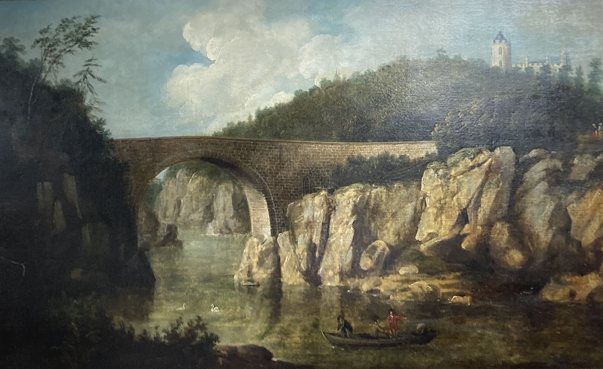 19th century English School, oil on canvas, Stone bridge across a gorge, a castellated county house in the distance, 53 x 90cm